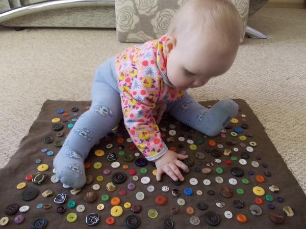 Developing mat with buttons for the baby